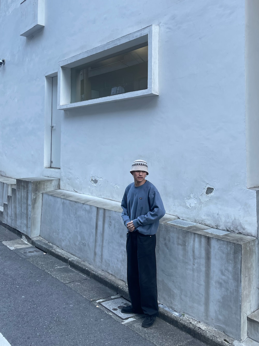 ブルー系のスウェット、ブラック系のデニムパンツを着用したメンズの冬コーディネートの2枚目の写真