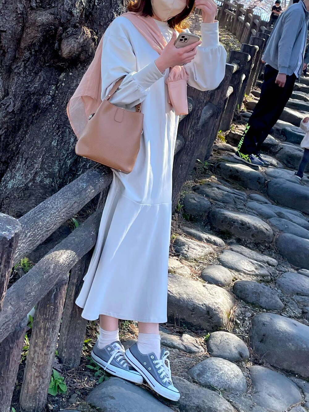 グレー系のスニーカー、ピンク系のシャツ/ブラウス、ホワイト系のワンピースを着用したレディースの春コーディネートの2枚目の写真