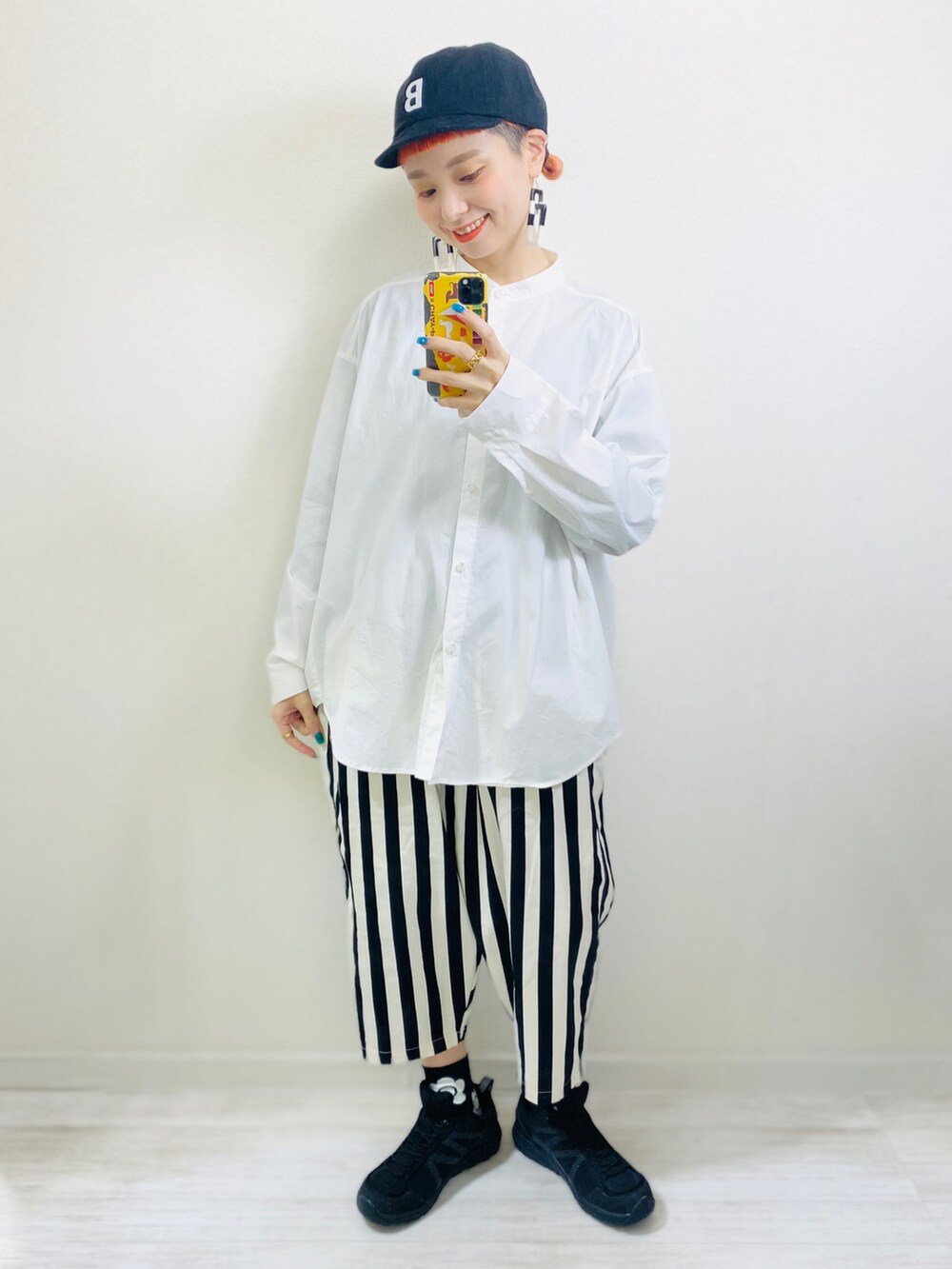 グリーン系のデニムジャケット、ホワイト系のシャツ/ブラウス、ブラック系のキャップを着用したレディースの春コーディネートの2枚目の写真