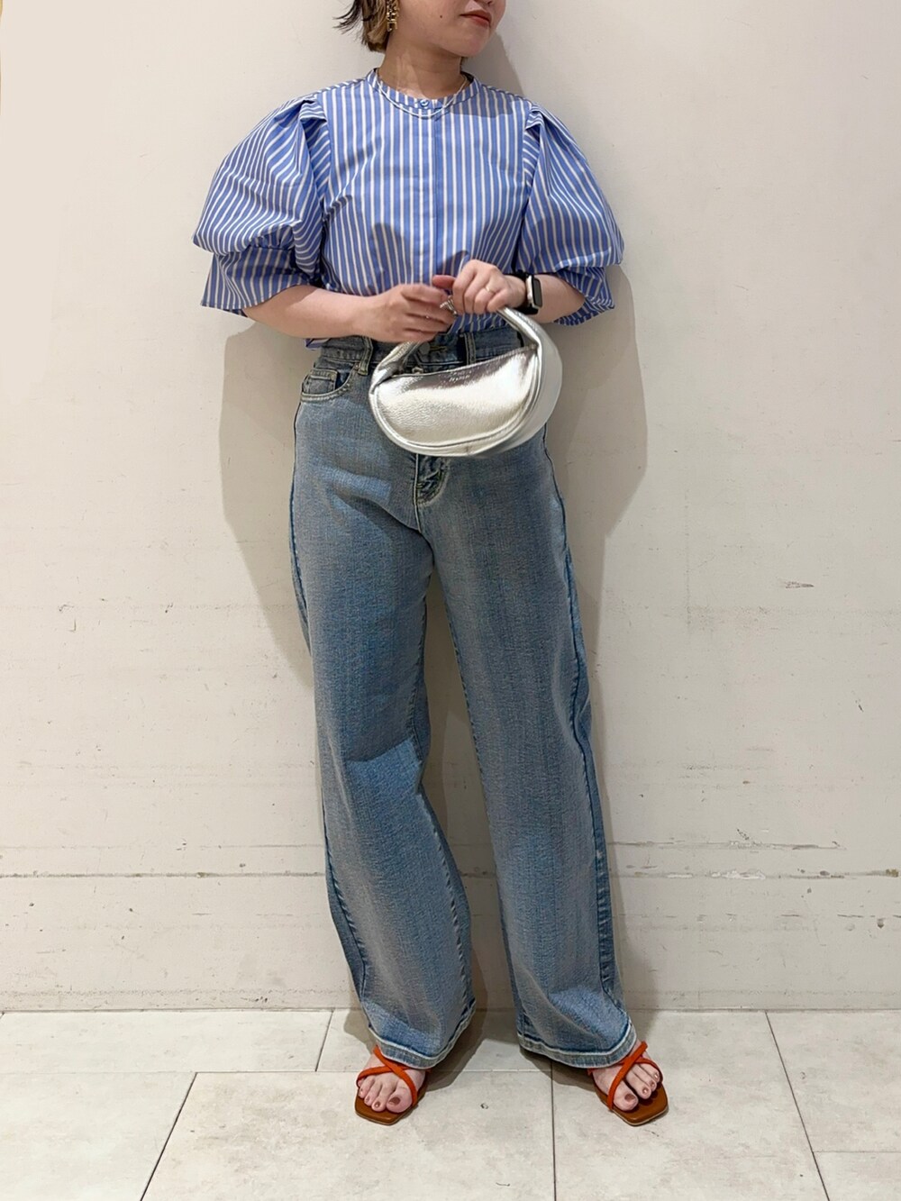 ブルー系のシャツ/ブラウス、ブルー系のデニムパンツ、シルバー系のハンドバッグを着用したレディースの春コーディネートの3枚目の写真