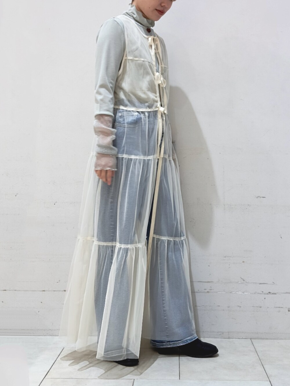 ブルー系のその他パンツ、ホワイト系のワンピース、グリーン系のTシャツ/カットソーを着用したレディースの冬コーディネートの2枚目の写真