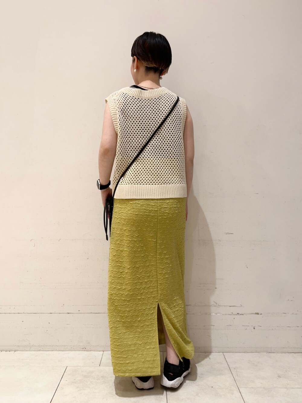 ホワイト系のタンクトップ、ホワイト系のニット/セーター、ブラック系のハンドバッグを着用したレディースの夏コーディネートの2枚目の写真