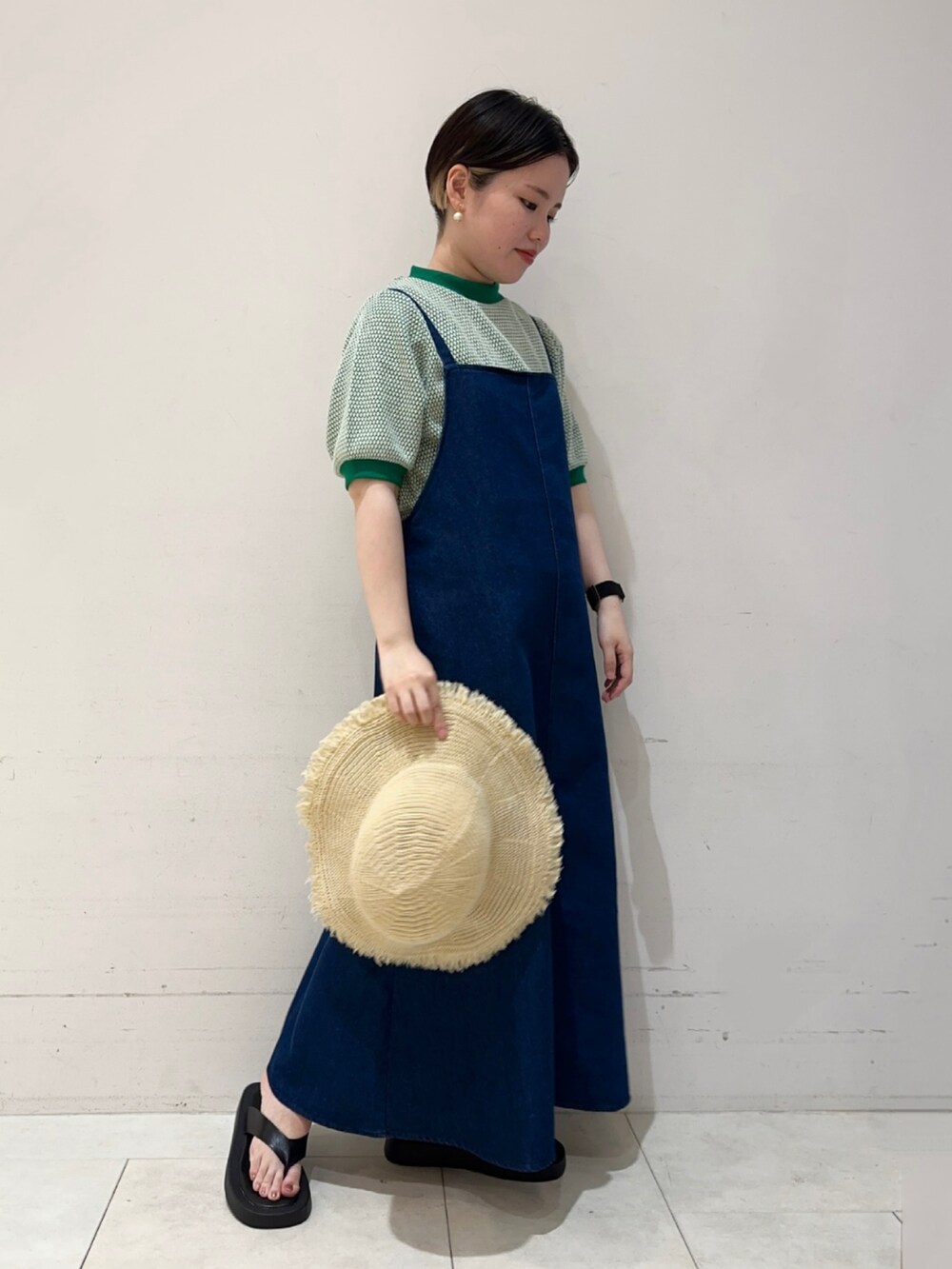 グリーン系のニット/セーター、ブルー系のワンピース、ブラック系のサンダルを着用したレディースの夏コーディネートの2枚目の写真