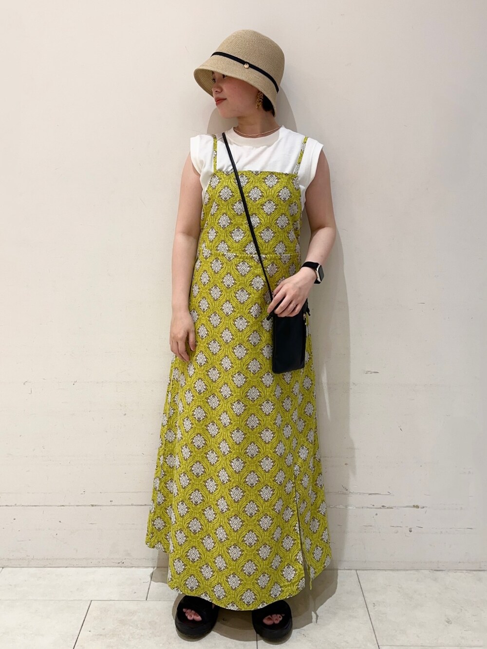 ホワイト系のTシャツ/カットソー、イエロー系のワンピース、ブラック系のハンドバッグを着用したレディースの春コーディネートの3枚目の写真