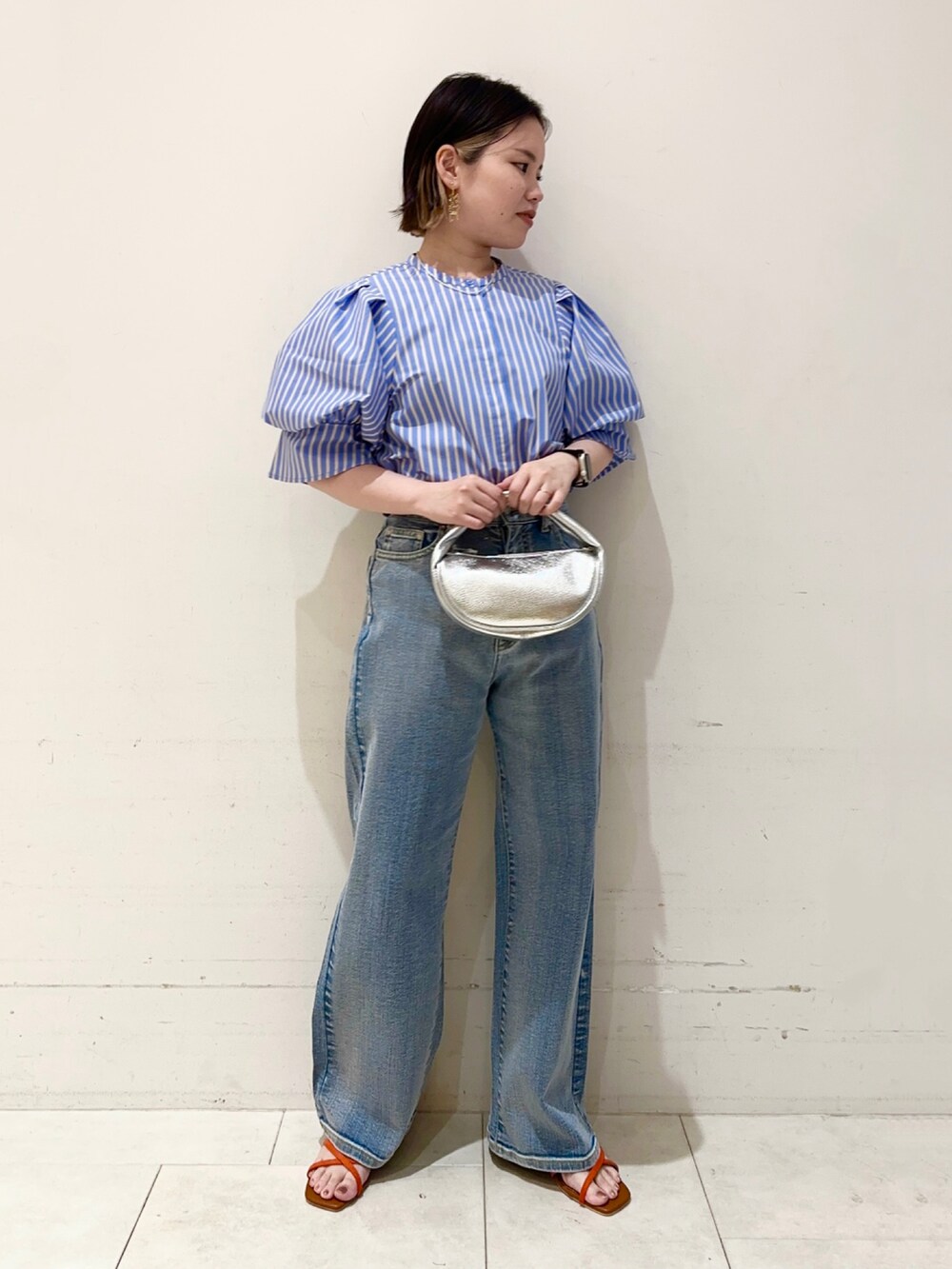 ブルー系のシャツ/ブラウス、ブルー系のデニムパンツ、シルバー系のハンドバッグを着用したレディースの春コーディネートの2枚目の写真