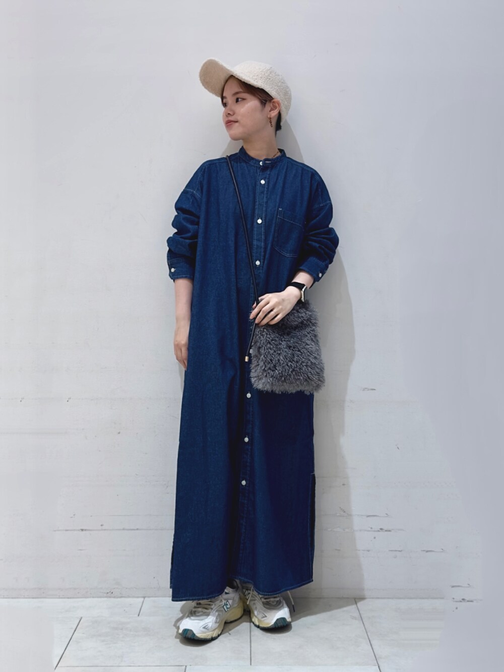 ブルー系のワンピース、グレー系のハンドバッグ、ホワイト系のハットを着用したレディースの秋コーディネートの2枚目の写真