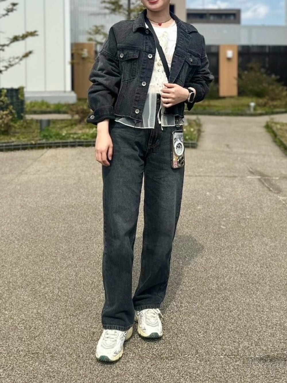 ホワイト系のスニーカー、ブラック系のデニムパンツ、ホワイト系のTシャツ/カットソーを着用したレディースの春コーディネートの2枚目の写真