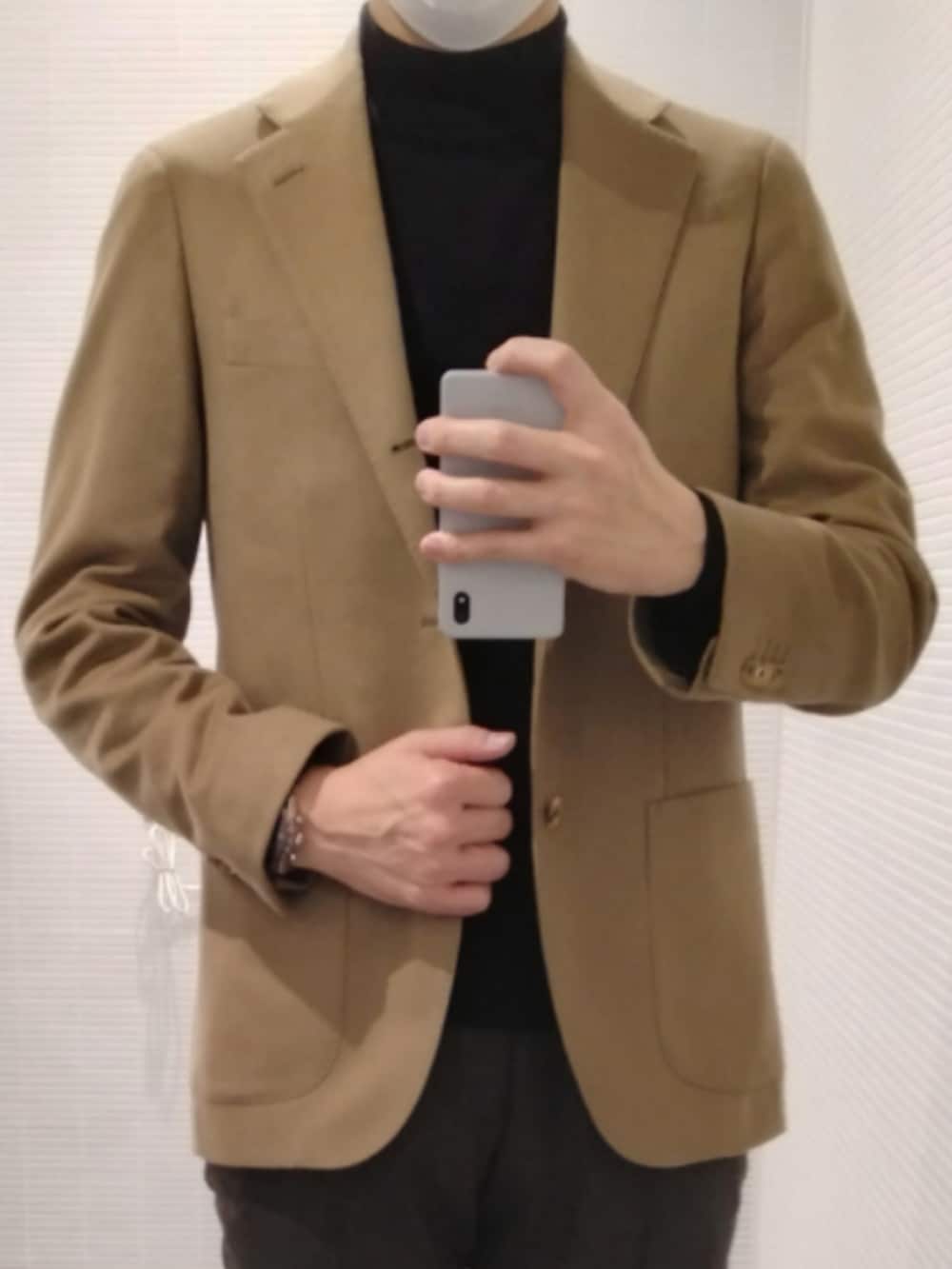 ブラック系のスリッポン、ブラウン系のスラックス、ベージュ系のテーラードジャケットを着用したメンズの春コーディネートの2枚目の写真