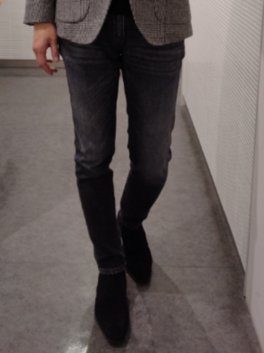 ブラック系のニット/セーター、グレー系のテーラードジャケット、ブラック系のデニムパンツを着用したメンズの春コーディネートの2枚目の写真