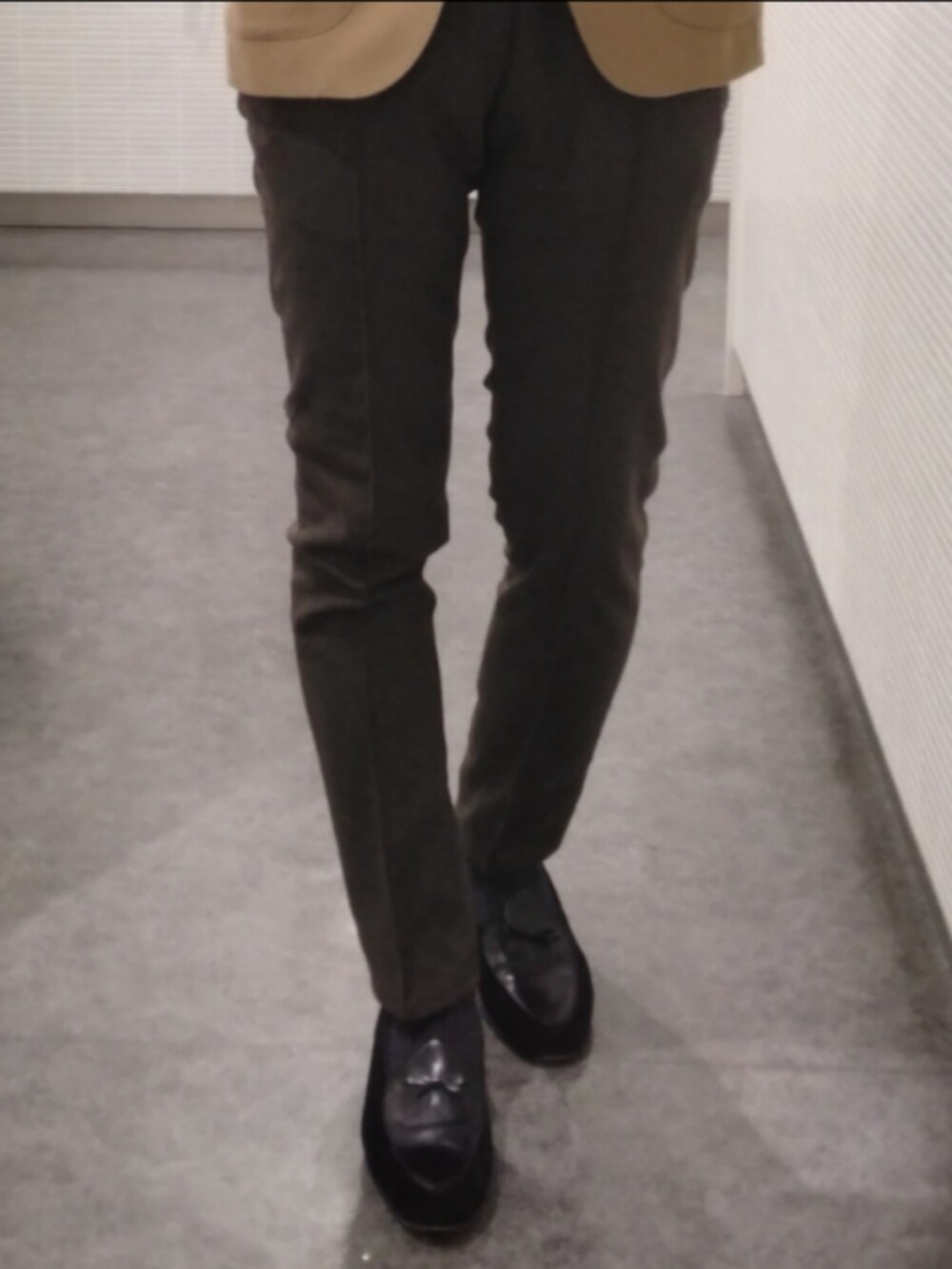 ブラック系のスリッポン、ブラウン系のスラックス、ベージュ系のテーラードジャケットを着用したメンズの春コーディネートの3枚目の写真