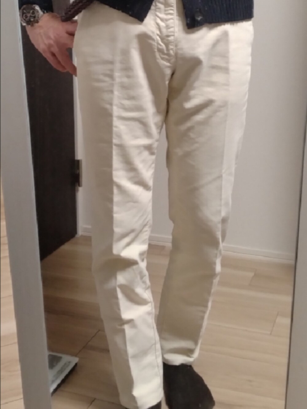 ブルー系のシャツ/ブラウス、ブルー系のニット/セーター、ホワイト系のチノパンツを着用したメンズの冬コーディネートの2枚目の写真