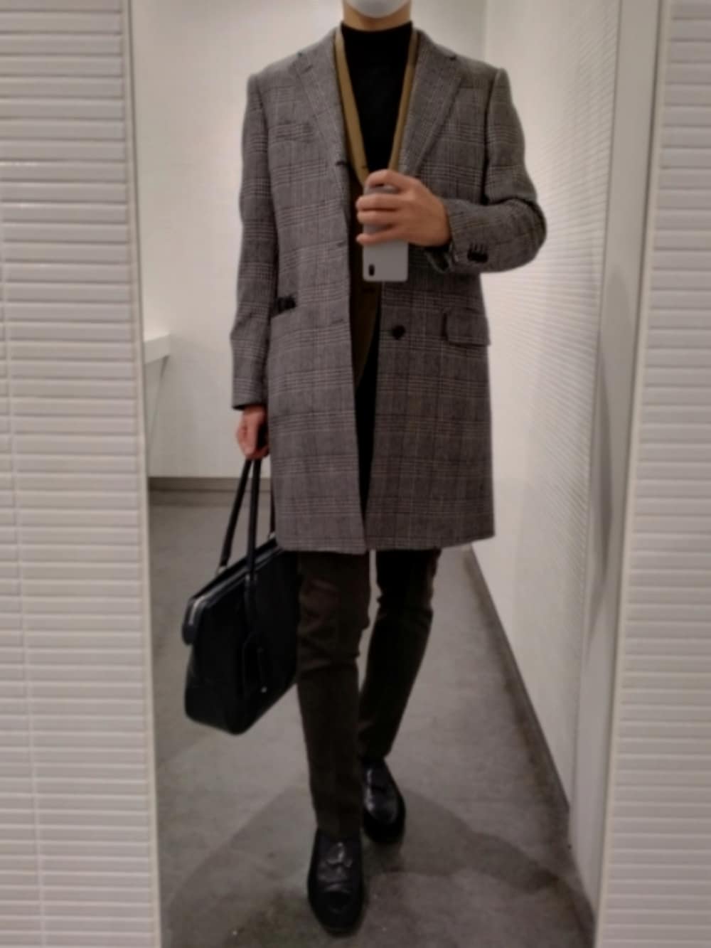 ブラック系のスリッポン、ブラウン系のスラックス、ベージュ系のテーラードジャケットを着用したメンズの春コーディネートの4枚目の写真