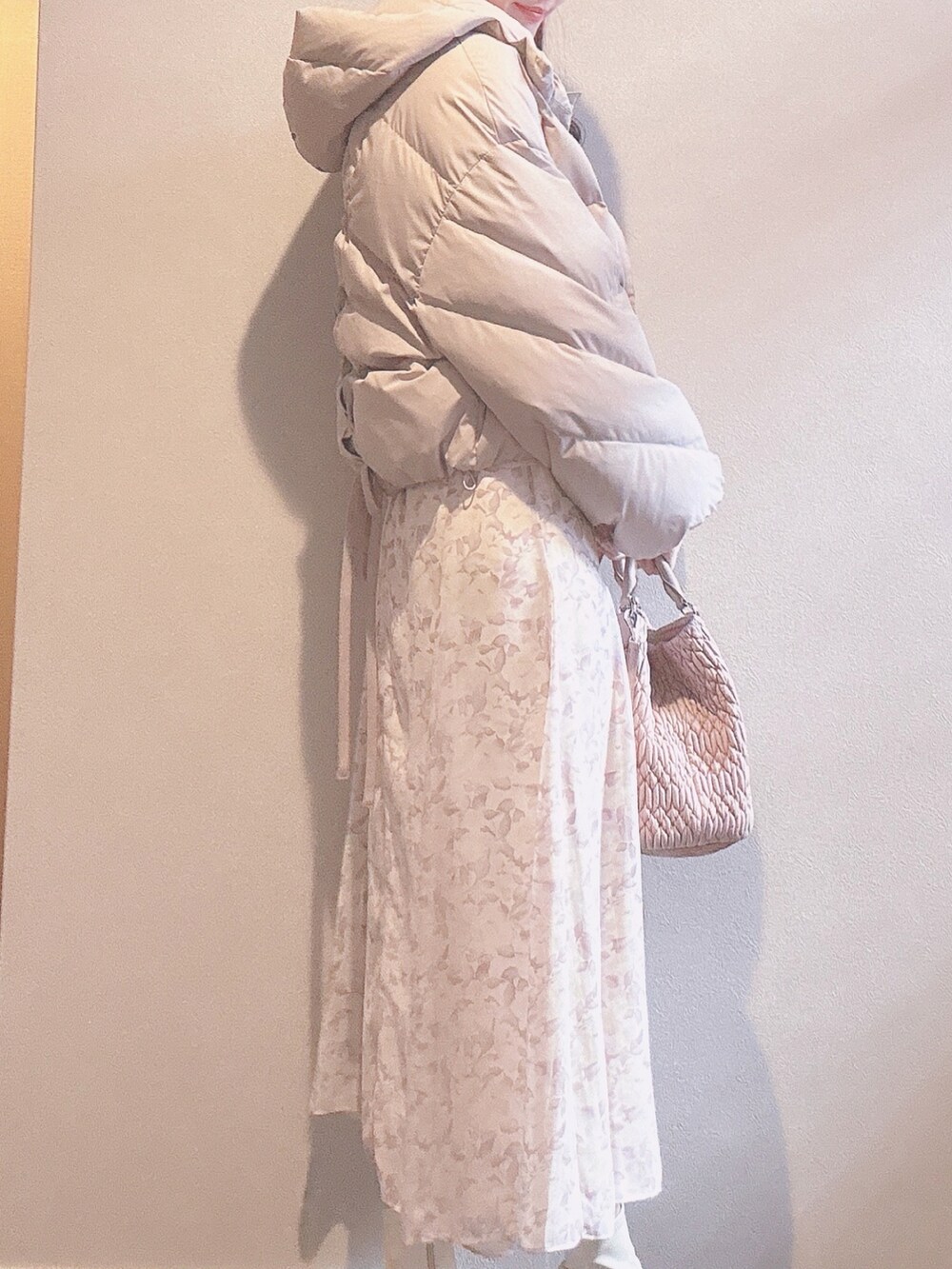 ピンク系のバッグ、パープル系のワンピース、ホワイト系のブーツを着用したレディースの冬コーディネートの3枚目の写真