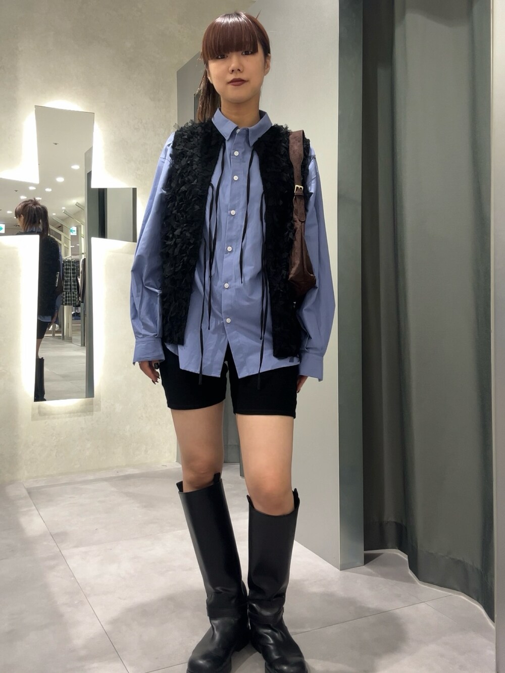 ブルー系のシャツ/ブラウス、ブラック系のベストを着用したレディースの秋コーディネートの2枚目の写真