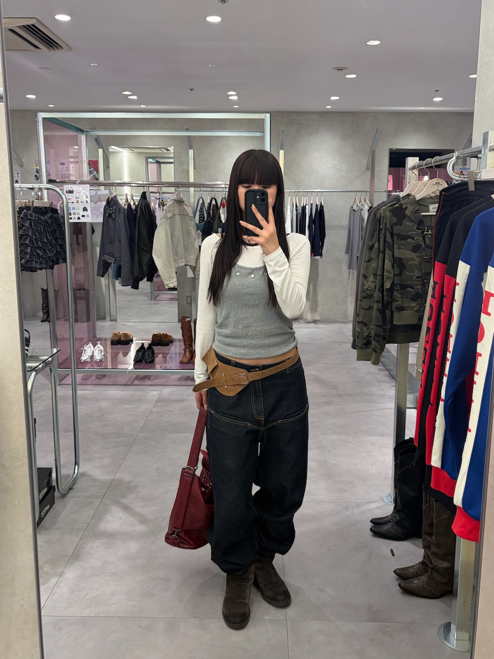 グレー系のTシャツ/カットソー、ブルー系のデニムパンツ、ブラック系のショルダーバッグを着用したレディースの冬コーディネートの2枚目の写真