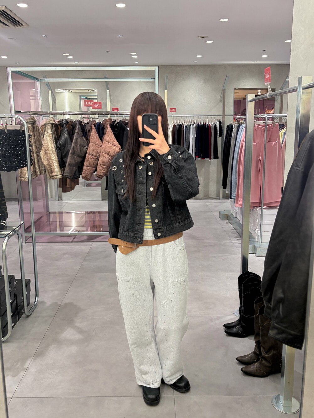 ブラック系のデニムジャケット、グレー系のスウェットパンツ、イエロー系のTシャツ/カットソーを着用したレディースの冬コーディネートの2枚目の写真