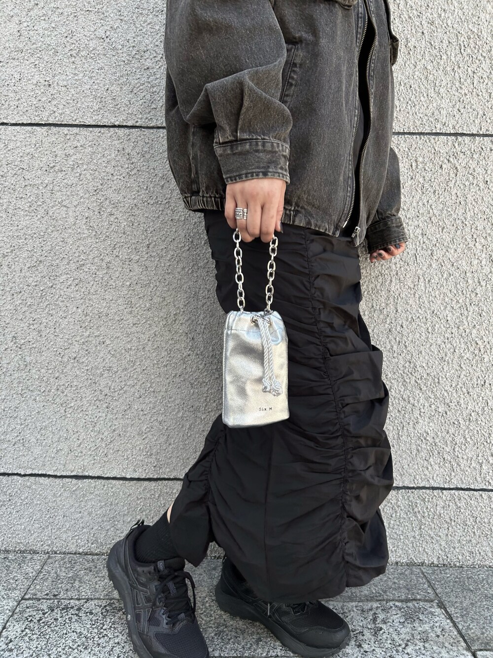 ブラウン系のブルゾン、ブラック系のスカート、シルバー系のハンドバッグを着用したレディースの秋コーディネートの2枚目の写真