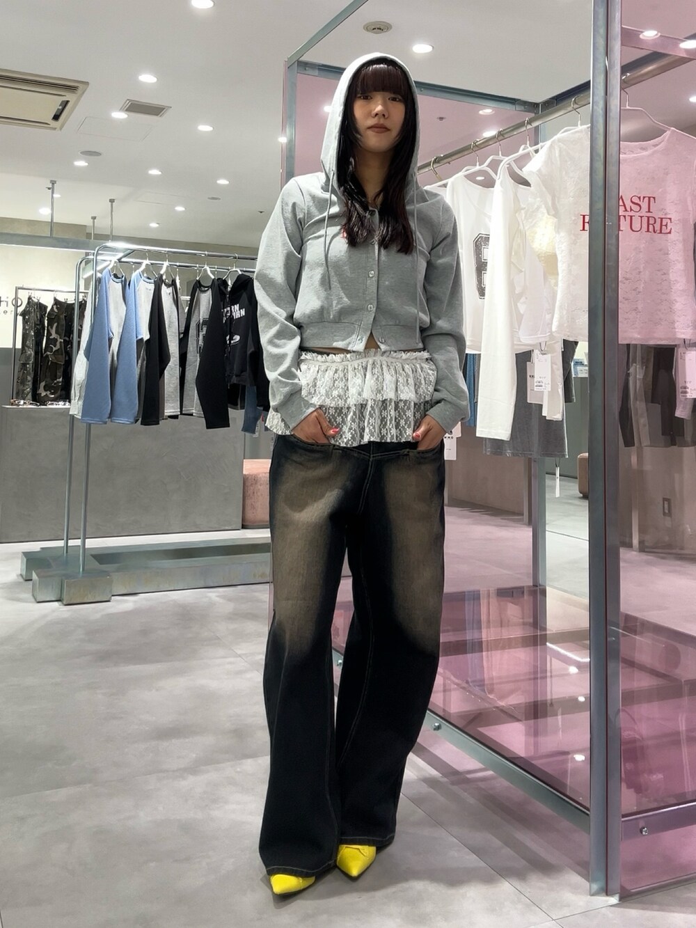 ブルー系のデニムパンツ、グレー系のパーカー、イエロー系のパンプスを着用したレディースの春コーディネートの2枚目の写真