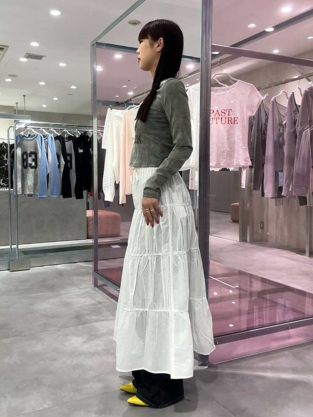 ホワイト系のスカート、イエロー系のパンプス、グレー系のTシャツ/カットソーを着用したレディースの春コーディネートの3枚目の写真