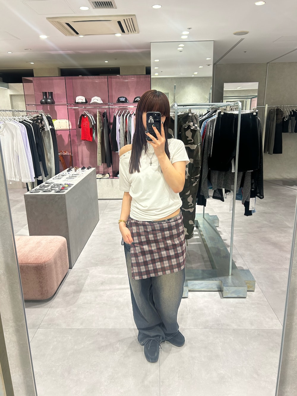 レッド系のスカート、ブルー系のデニムパンツ、ホワイト系のTシャツ/カットソーを着用したレディースの春コーディネートの2枚目の写真