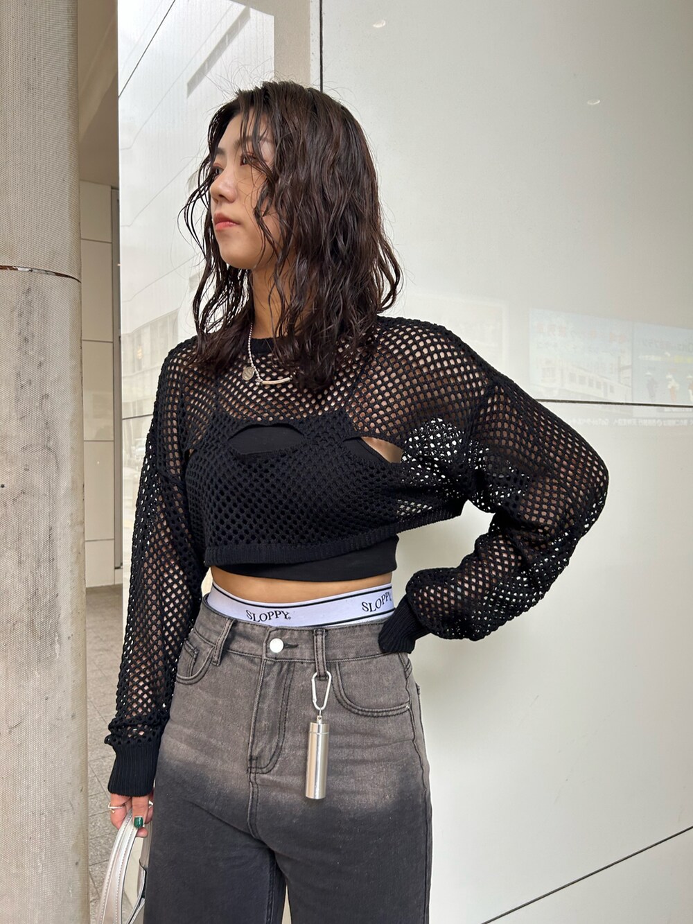 ブラック系のデニムパンツ、ブラック系のカーディガン/ボレロ、シルバー系のハンドバッグを着用したレディースの春コーディネートの3枚目の写真