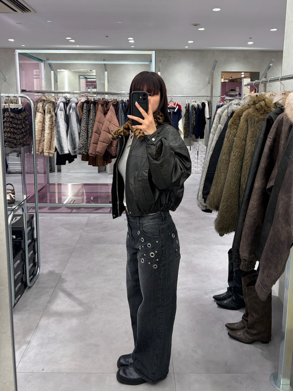 ブラック系のデニムパンツ、ブラック系のブルゾンを着用したレディースの冬コーディネートの2枚目の写真