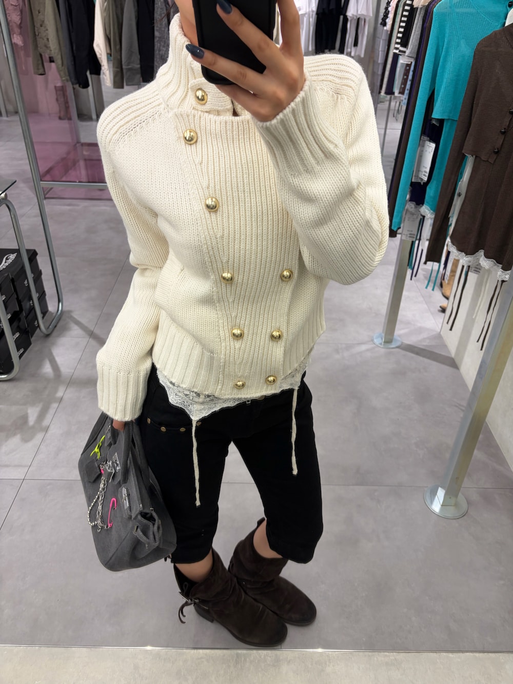 ホワイト系のニット/セーター、ブラック系のその他パンツ、グレー系のハンドバッグを着用したレディースの秋コーディネートの2枚目の写真