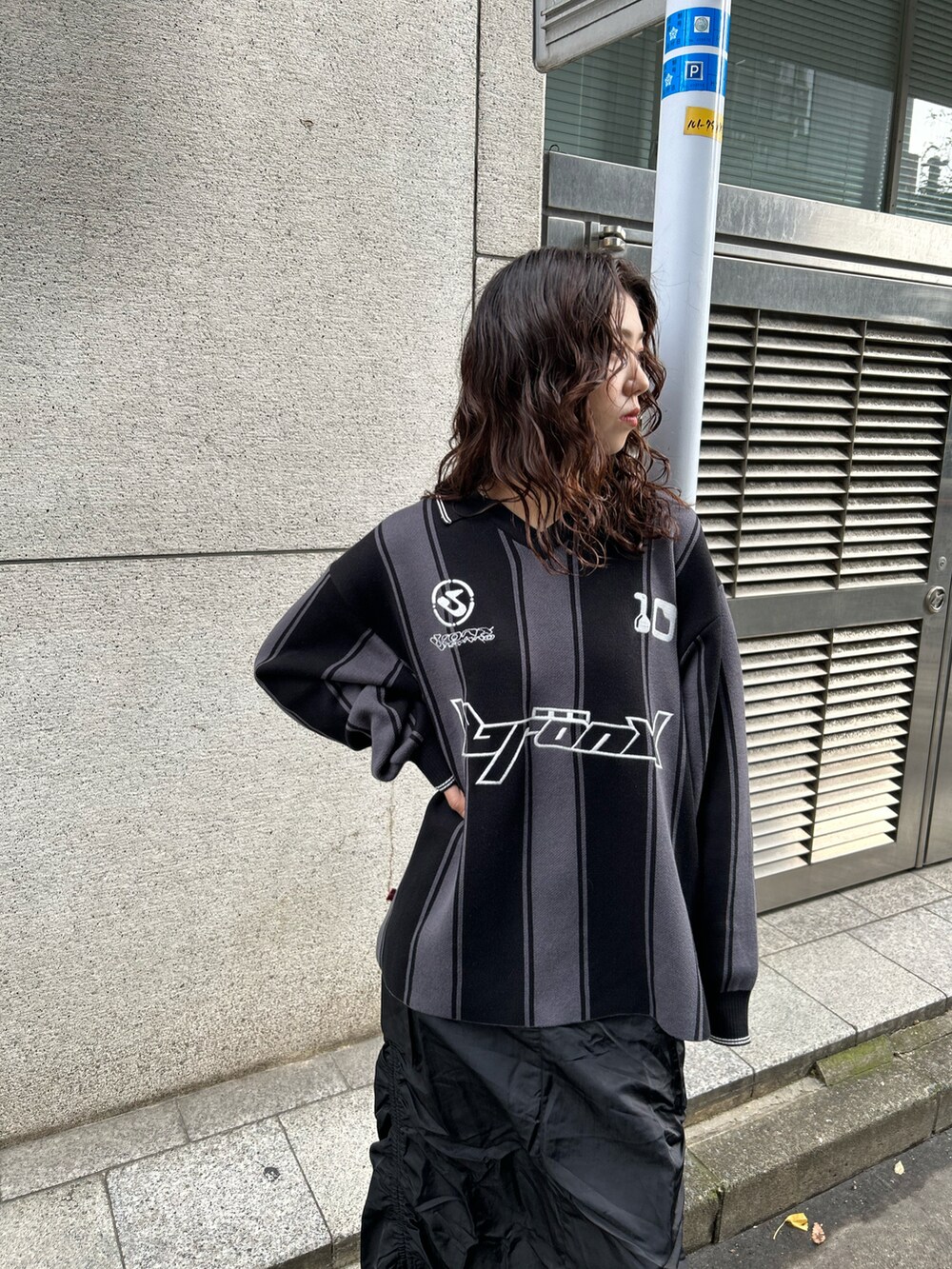 ブラック系のニット/セーター、ブラック系のスカートを着用したレディースの秋コーディネートの2枚目の写真