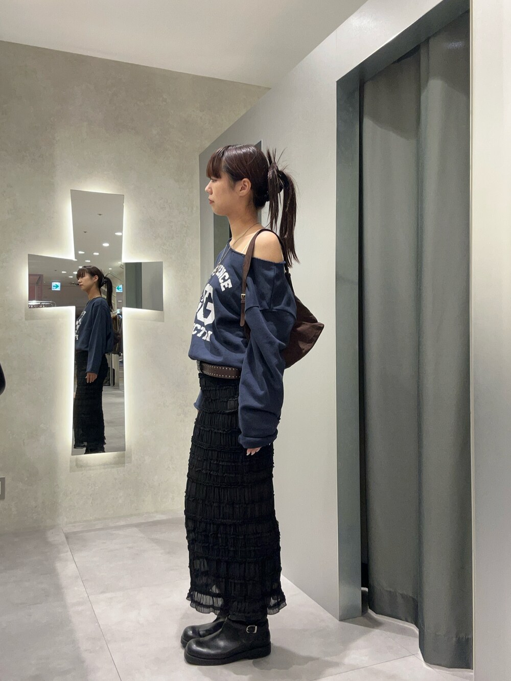 ブラック系のスカート、ブルー系のスウェットを着用したレディースの秋コーディネートの2枚目の写真