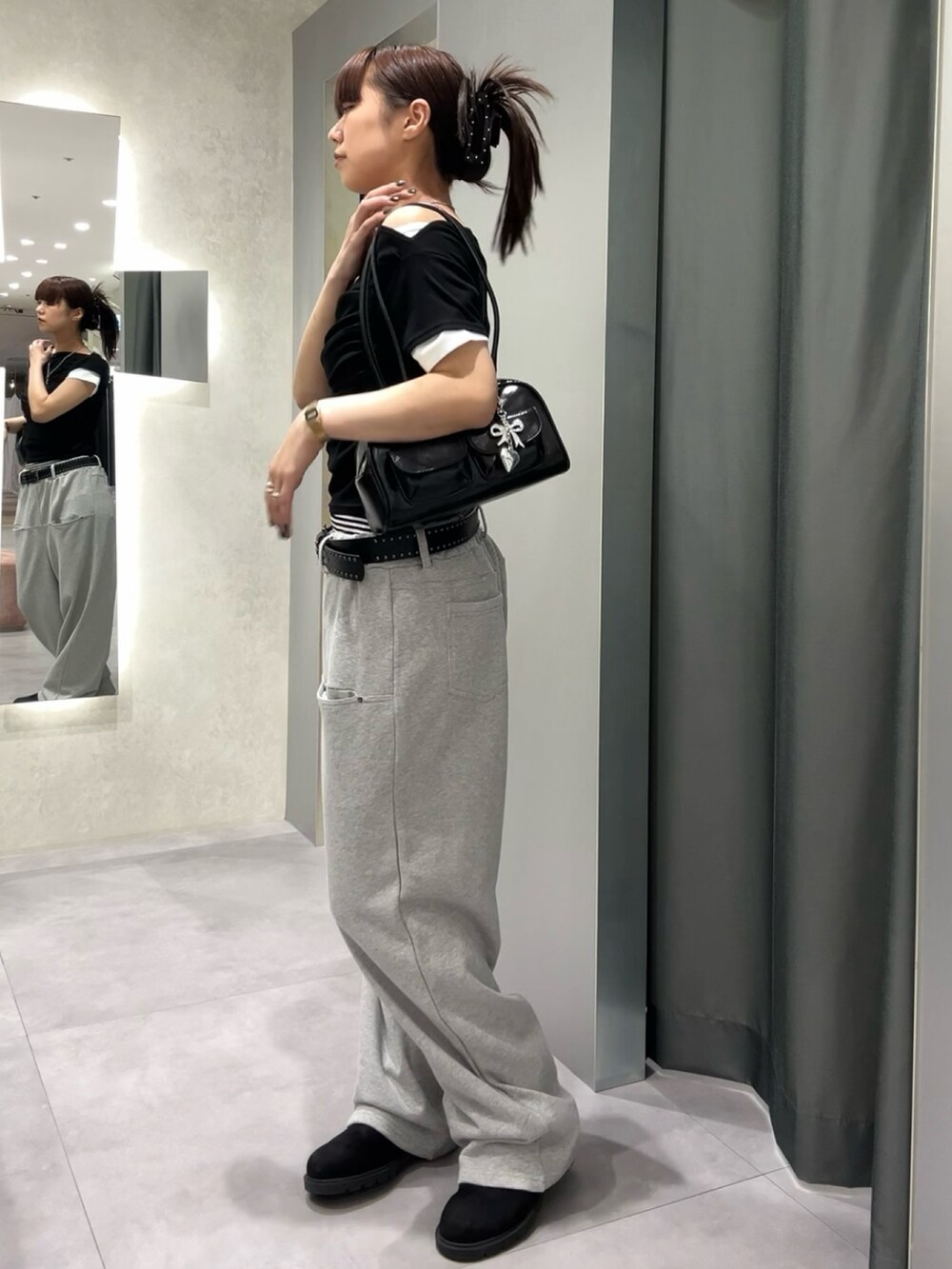 グレー系のスウェットパンツ、ブラック系のTシャツ/カットソー、ブラック系のベルトを着用したレディースの春コーディネートの3枚目の写真