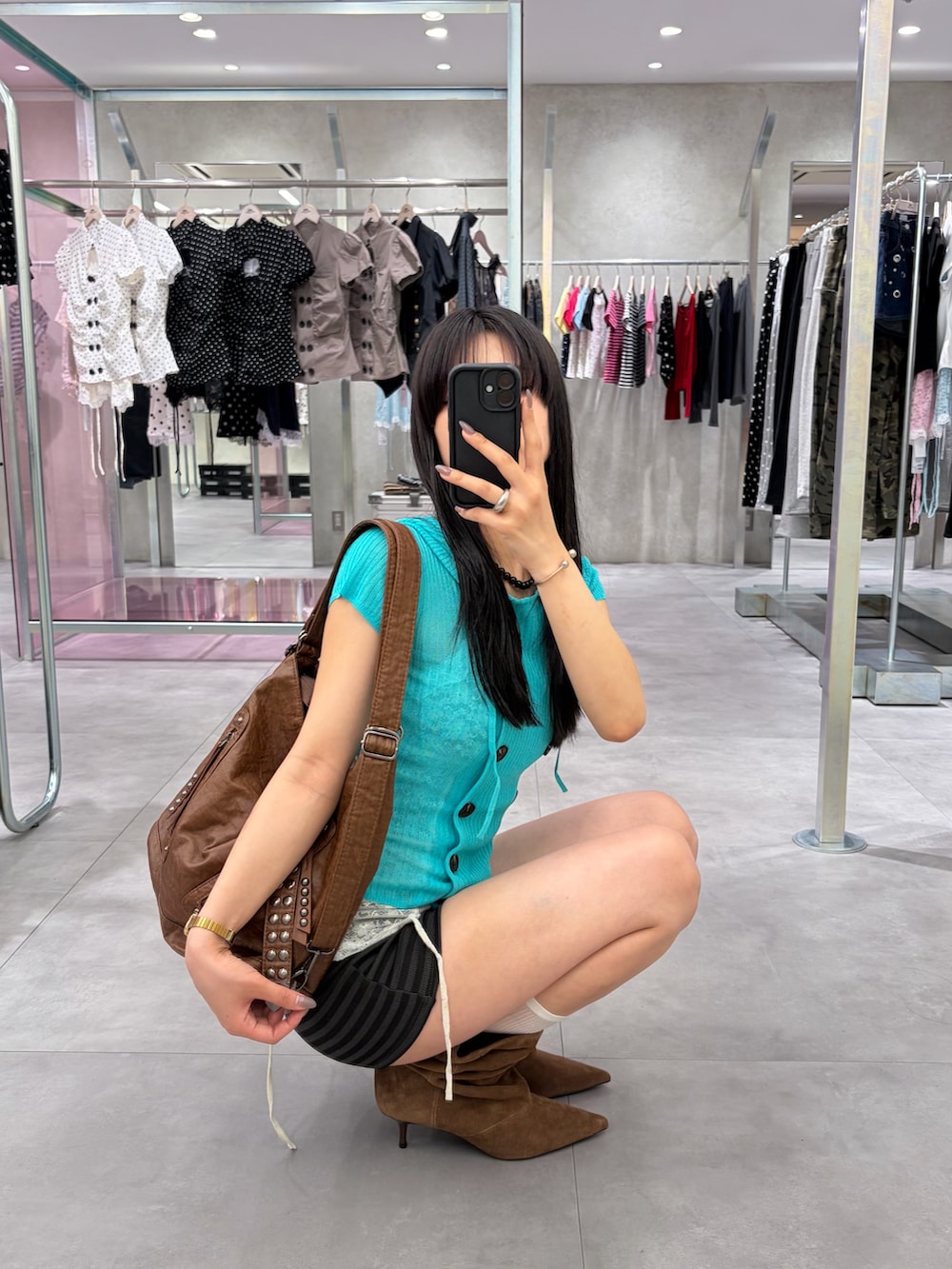ブルー系のパーカー、ホワイト系のキャミソール、ブラック系のその他パンツを着用したレディースの春コーディネートの2枚目の写真