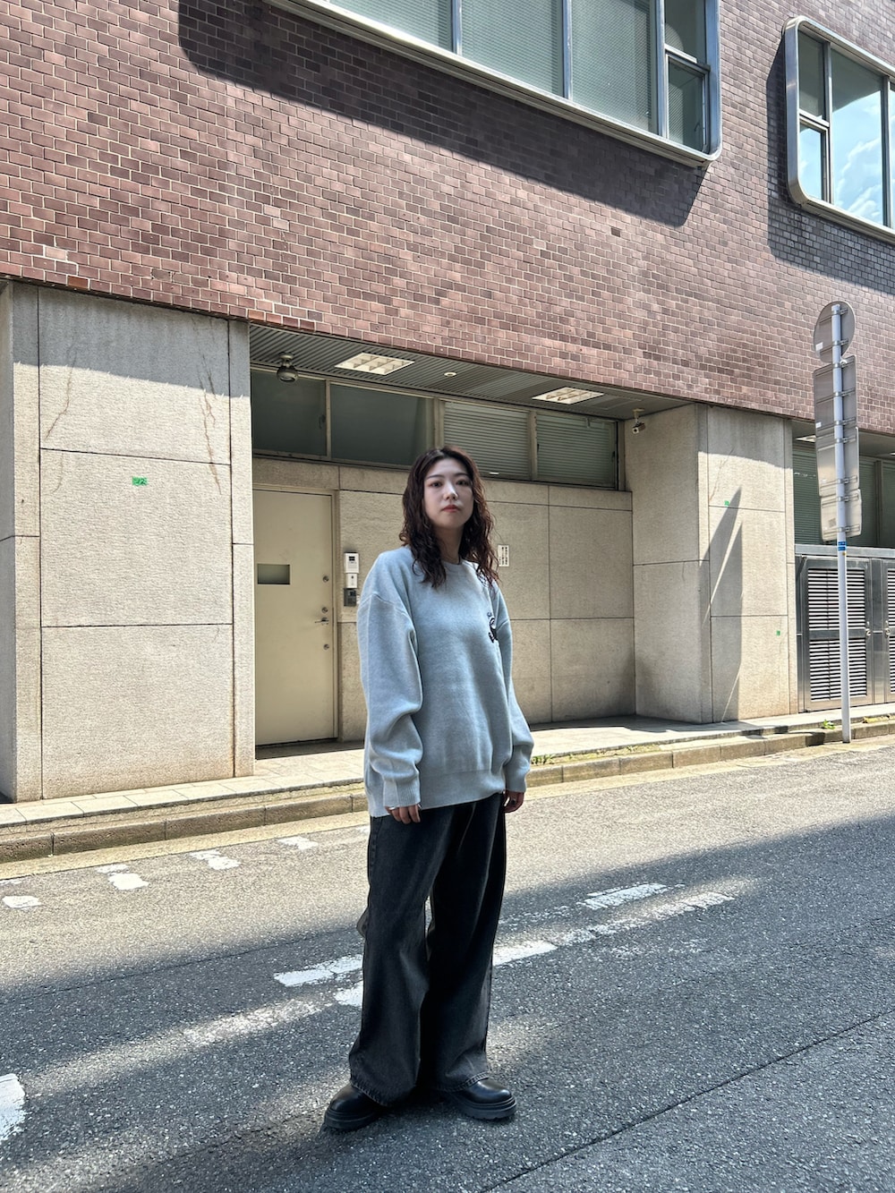 グレー系のニット/セーター、ブラウン系のデニムパンツを着用したレディースの秋コーディネートの3枚目の写真