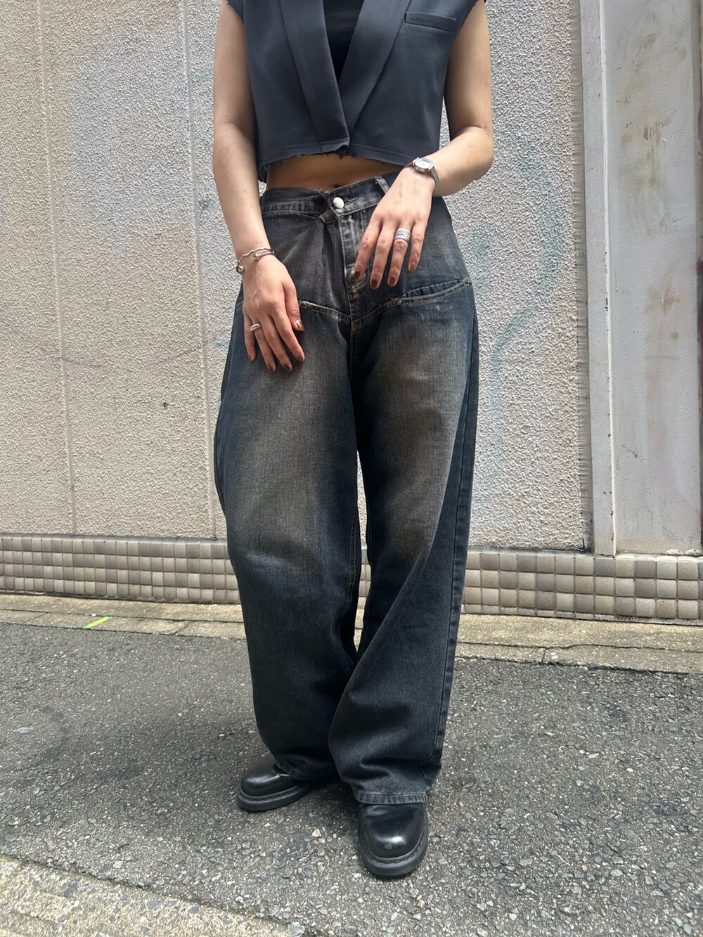 ブルー系のデニムパンツ、グレー系のベストを着用したレディースの夏コーディネートの2枚目の写真