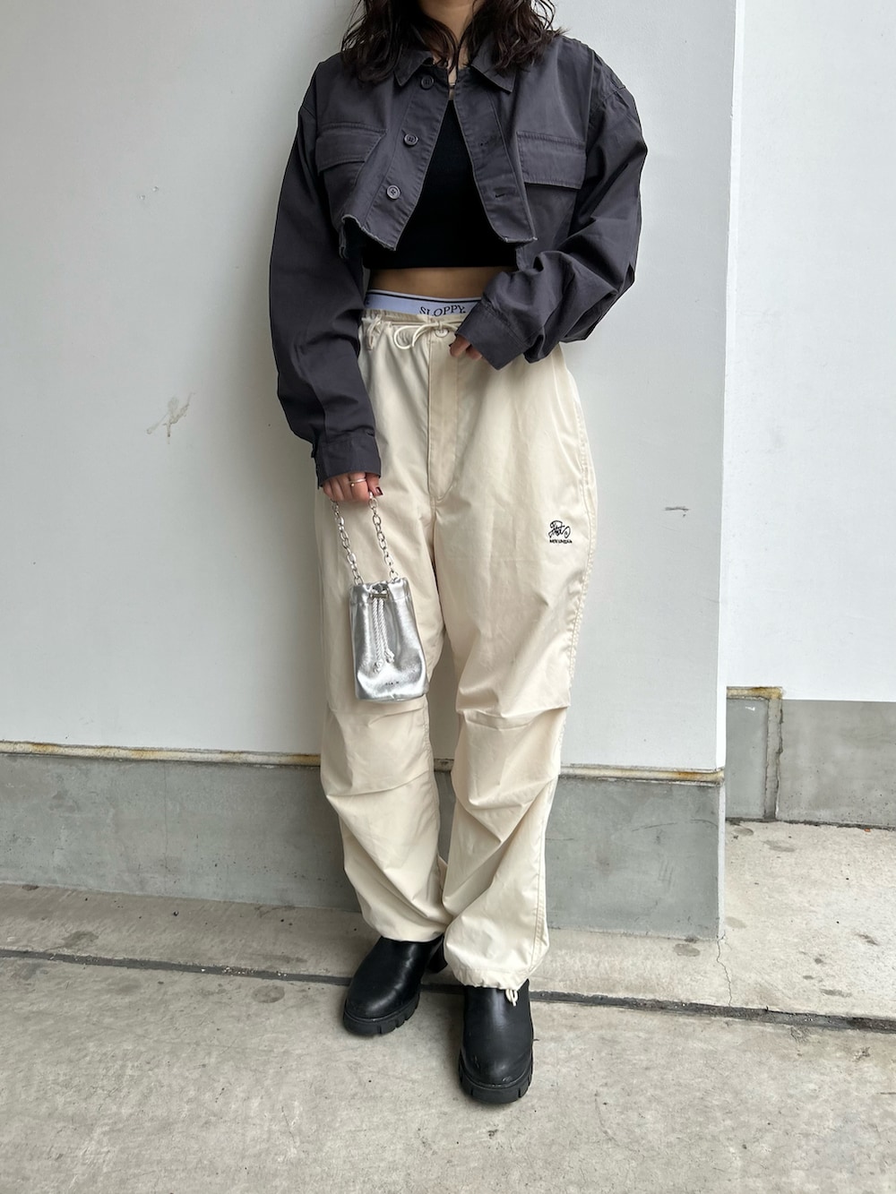 ホワイト系のカーゴパンツ、グレー系のミリタリージャケット、シルバー系のハンドバッグを着用したレディースの春コーディネートの2枚目の写真