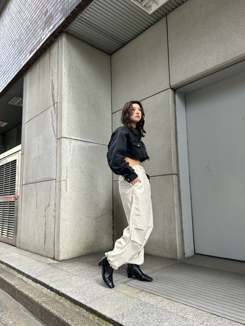 ホワイト系のカーゴパンツ、ブラック系のデニムジャケットを着用したレディースの夏コーディネートの2枚目の写真