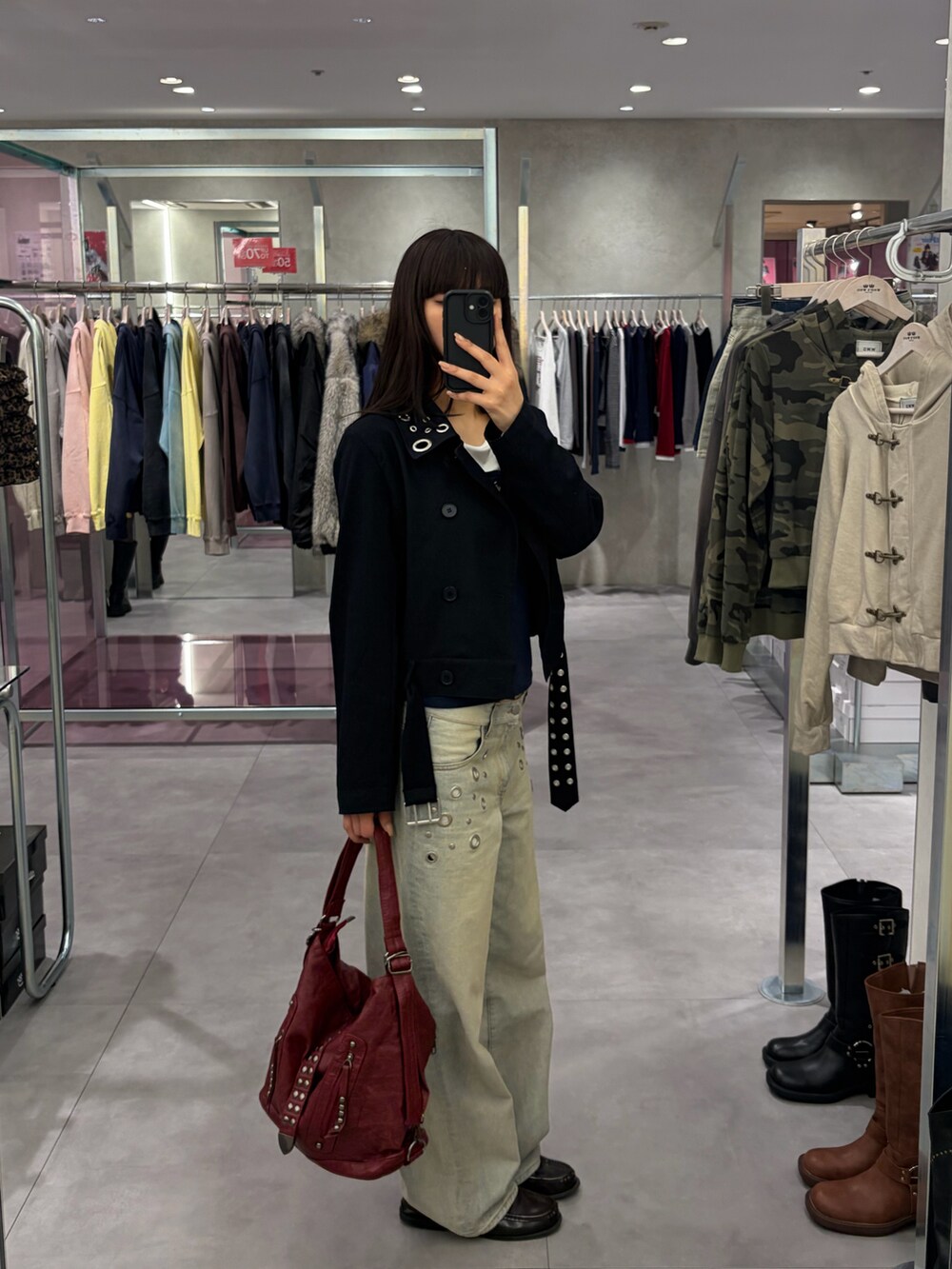 ブルー系のデニムパンツ、ブラック系のショルダーバッグ、ブルー系のピーコートを着用したレディースの冬コーディネートの2枚目の写真