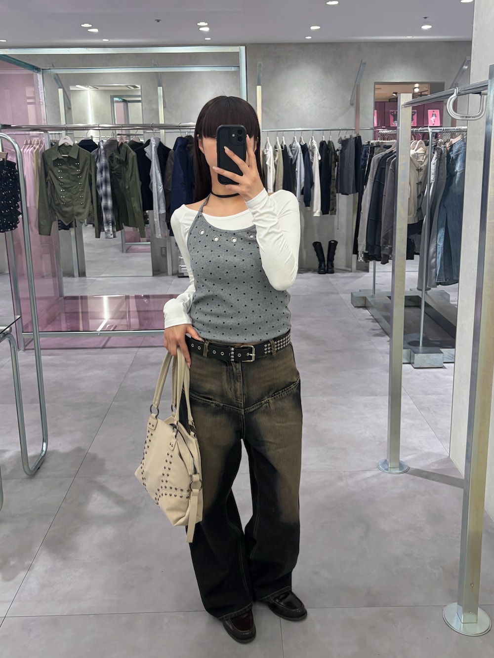 ブルー系のデニムパンツ、ホワイト系のショルダーバッグ、グレー系のTシャツ/カットソーを着用したレディースの春コーディネートの2枚目の写真