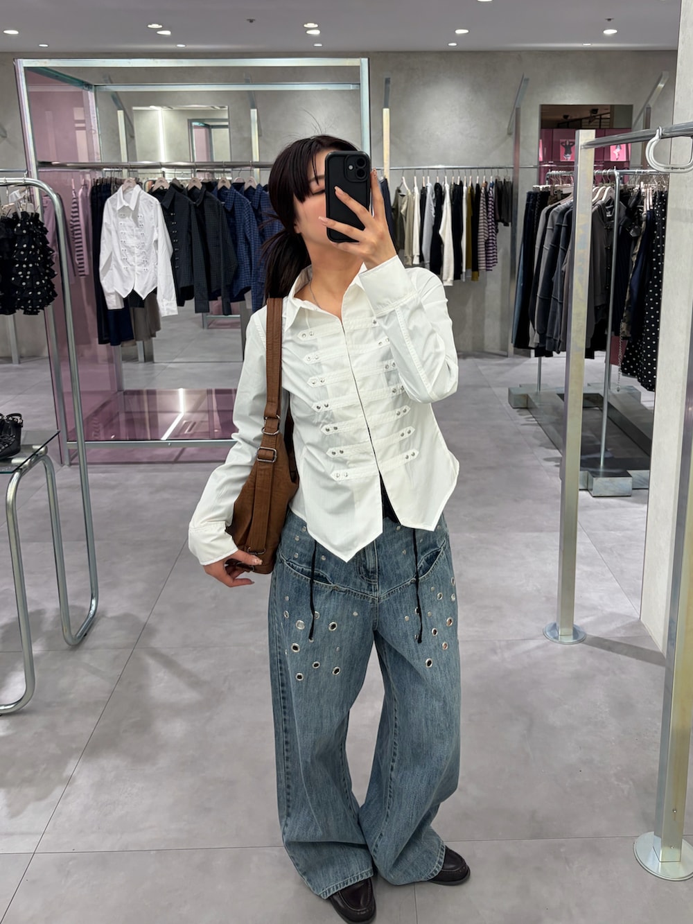 ホワイト系のシャツ/ブラウス、ブルー系のデニムパンツ、ブラウン系のショルダーバッグを着用したレディースの春コーディネートの2枚目の写真