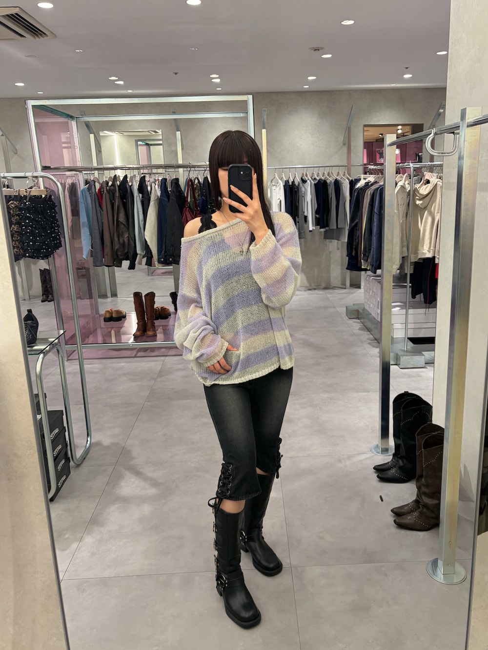 ブラック系のデニムパンツ、グレー系のニット/セーターを着用したレディースの春コーディネートの2枚目の写真