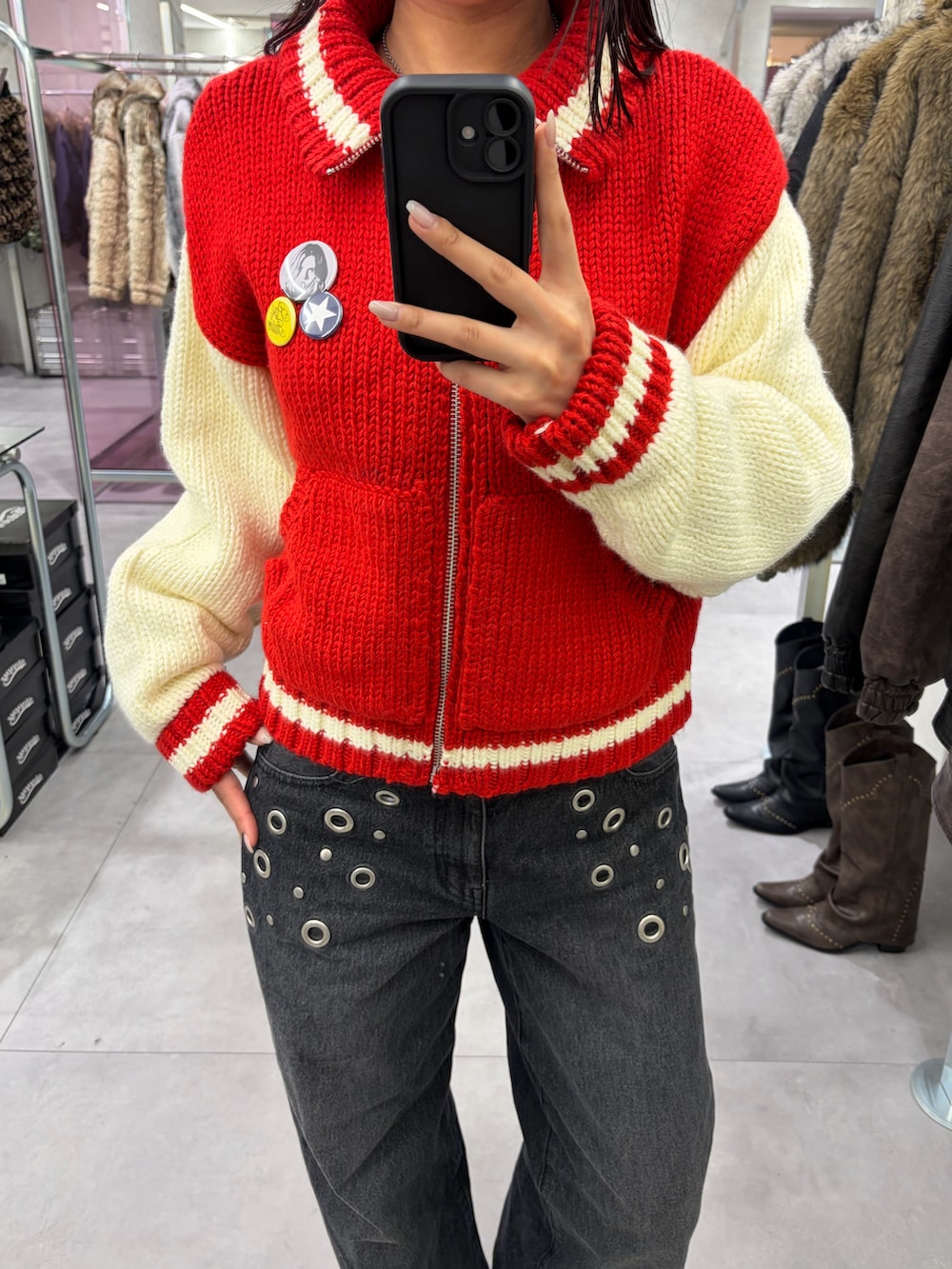 ブラック系のデニムパンツ、レッド系のスタジャンを着用したレディースの冬コーディネートの3枚目の写真