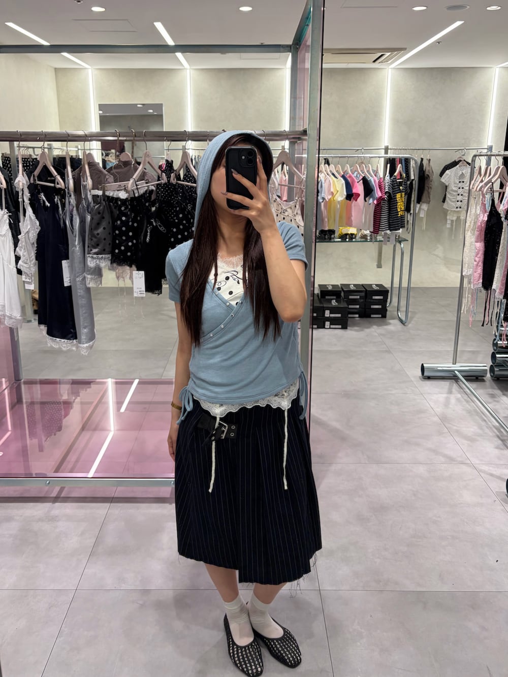 ブルー系のスカート、ブルー系のTシャツ/カットソー、ホワイト系のキャミソールを着用したレディースの春コーディネートの2枚目の写真