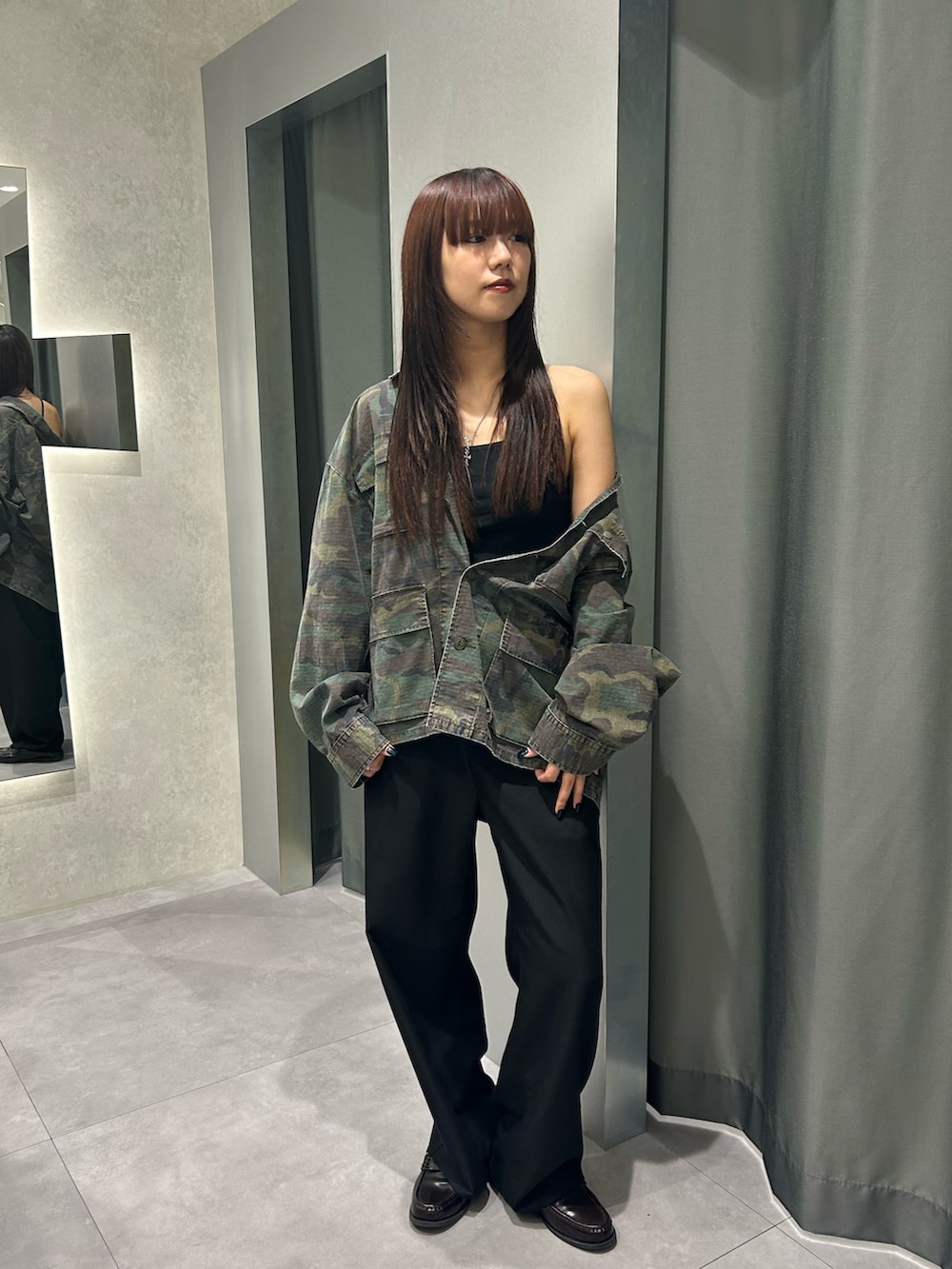 グリーン系のミリタリージャケット、グレー系のスラックスを着用したレディースの秋コーディネートの2枚目の写真