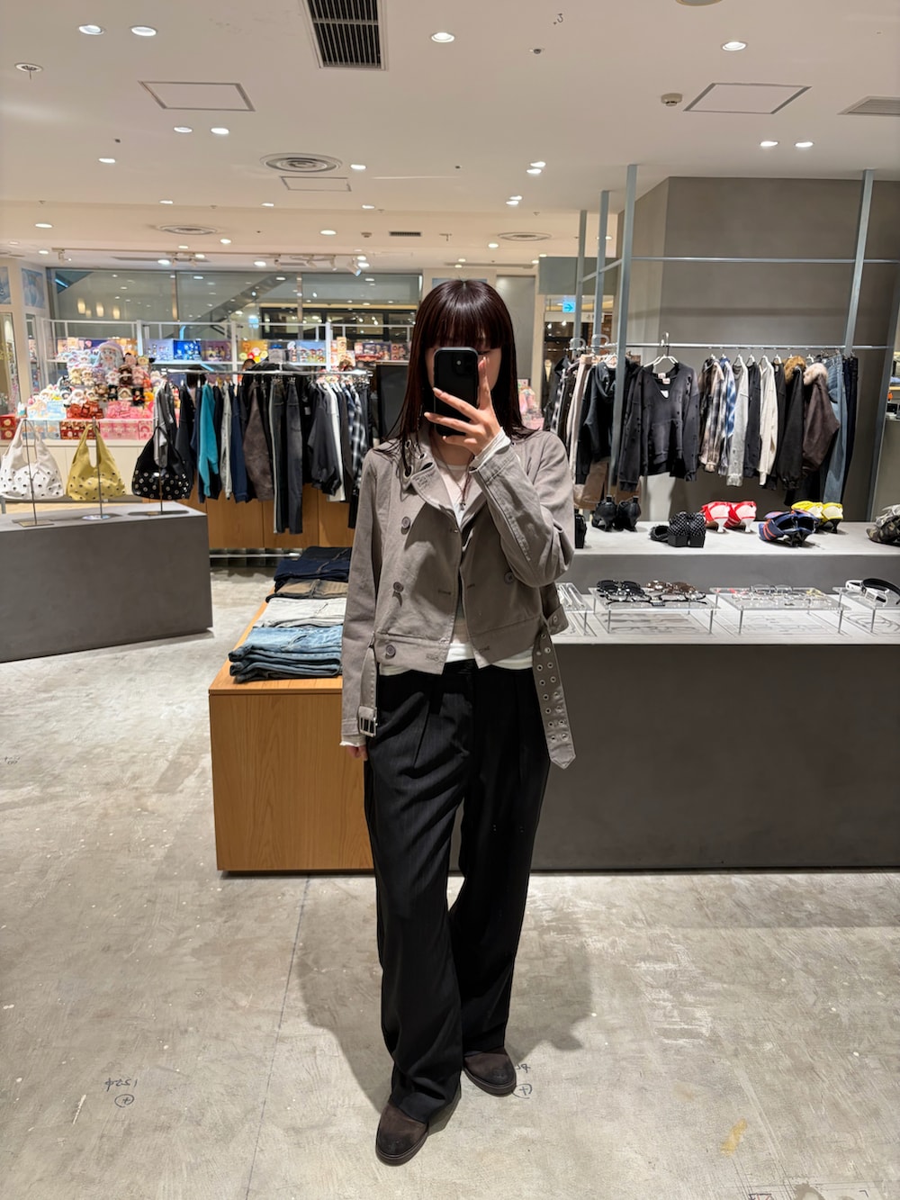 ブラック系のスラックス、グレー系のピーコートを着用したレディースの春コーディネートの2枚目の写真