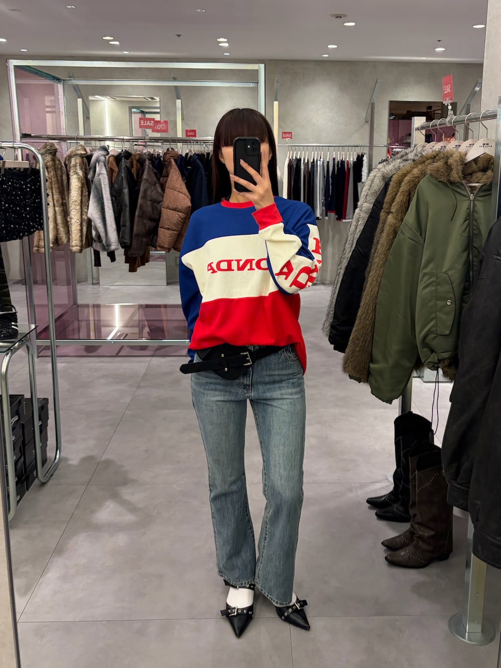 ブルー系のデニムパンツ、ブルー系のTシャツ/カットソー、ブラック系のベルトを着用したレディースの冬コーディネートの2枚目の写真