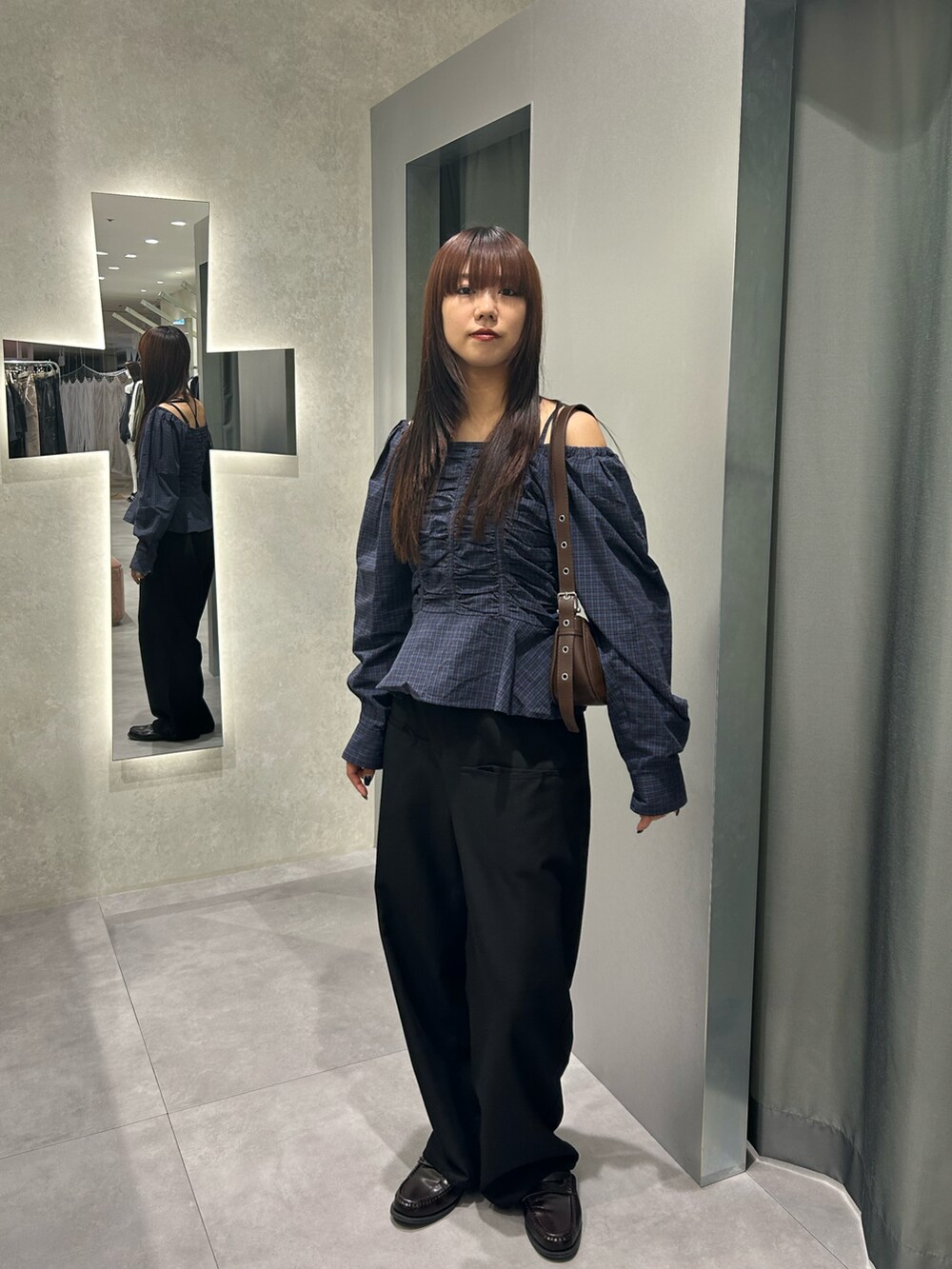 グレー系のスラックス、ブルー系のシャツ/ブラウスを着用したレディースの秋コーディネートの2枚目の写真