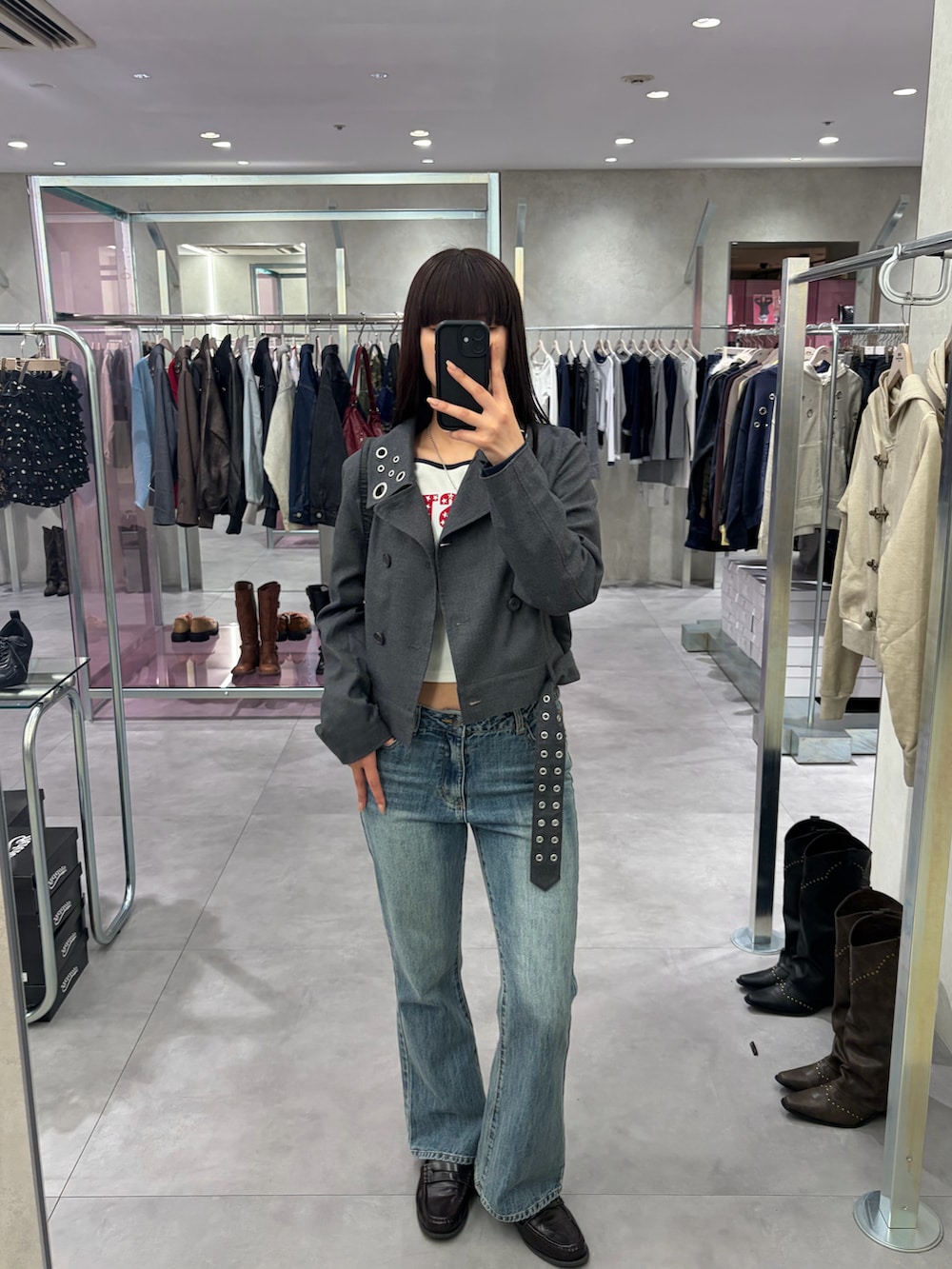 グレー系のピーコート、ブルー系のデニムパンツを着用したレディースの春コーディネートの2枚目の写真