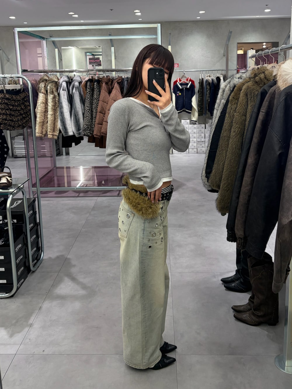 グレー系のニット/セーター、ブラック系のデニムパンツを着用したレディースの冬コーディネートの2枚目の写真