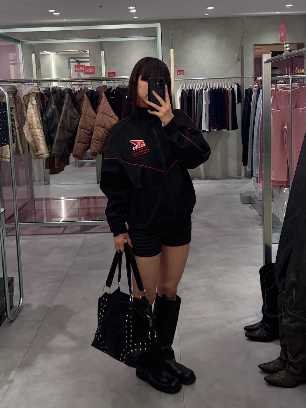 ブラック系のその他アウター、ブラック系のボストンバッグ、ブラック系のその他パンツを着用したレディースの冬コーディネートの2枚目の写真