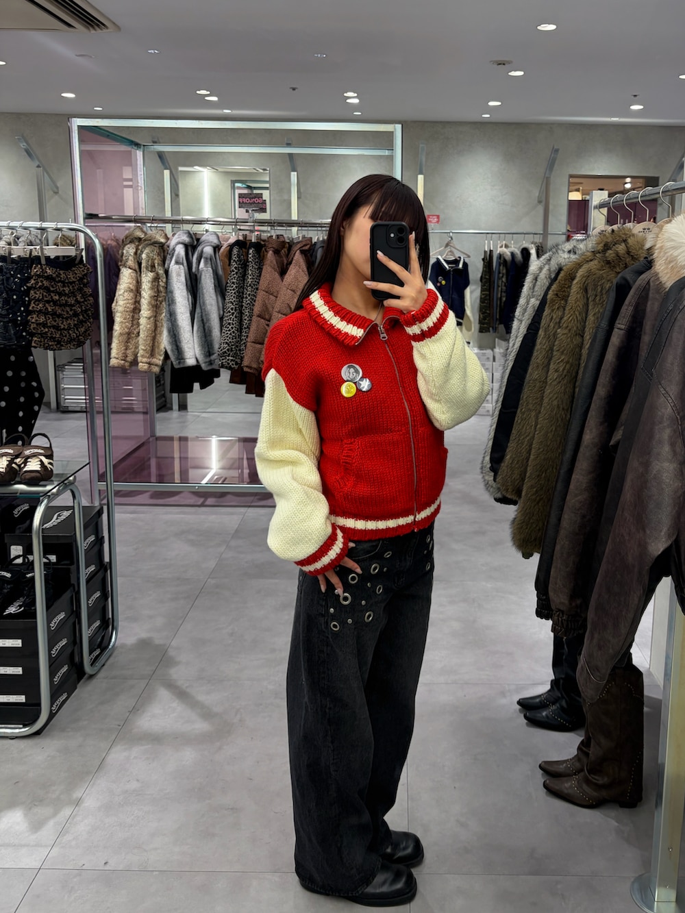 ブラック系のデニムパンツ、レッド系のスタジャンを着用したレディースの冬コーディネートの2枚目の写真