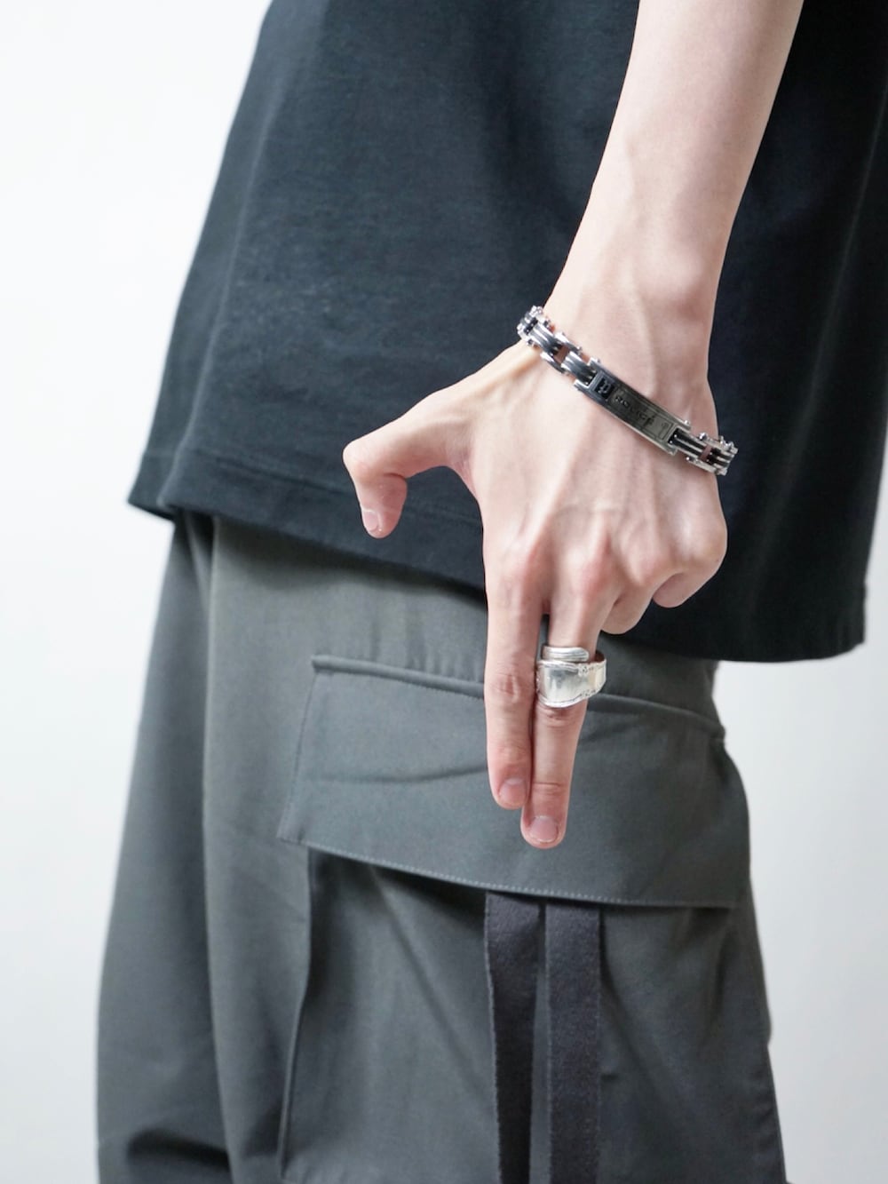 ホワイト系のスニーカー、グレー系のカーゴパンツ、ホワイト系のTシャツ/カットソーを着用したメンズの夏コーディネートの2枚目の写真